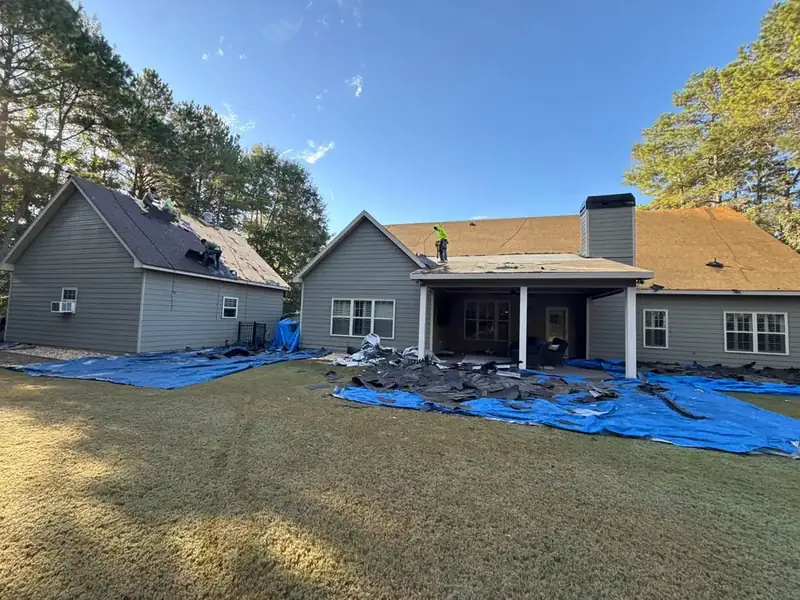 Roof tear-off with protective tarps on lawn — Haines City FL roof installation process Polk County